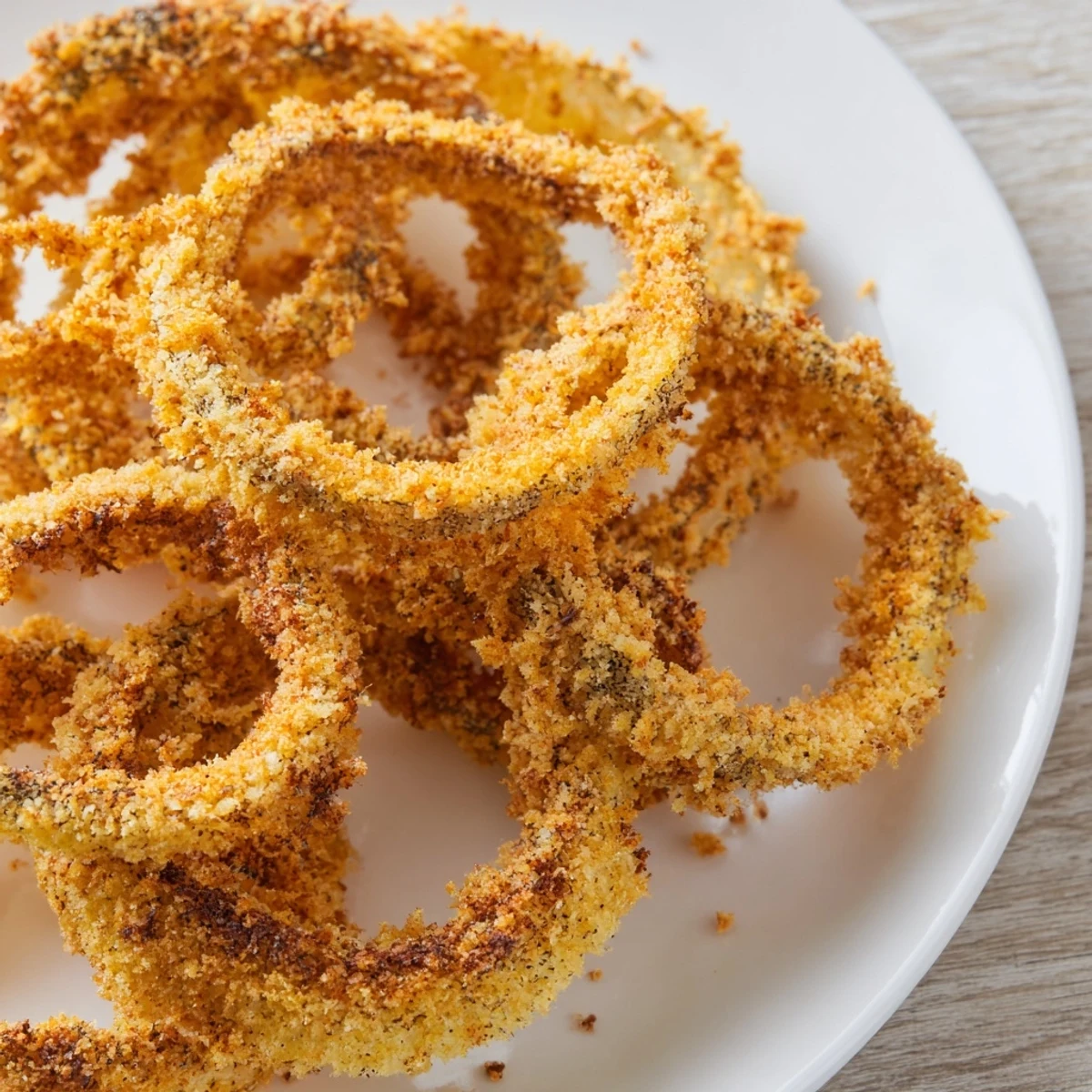 Golden Crispy Baked Onion Rings with Breadcrumbs ready to serve, featuring a crunchy texture and savory seasoned coating.