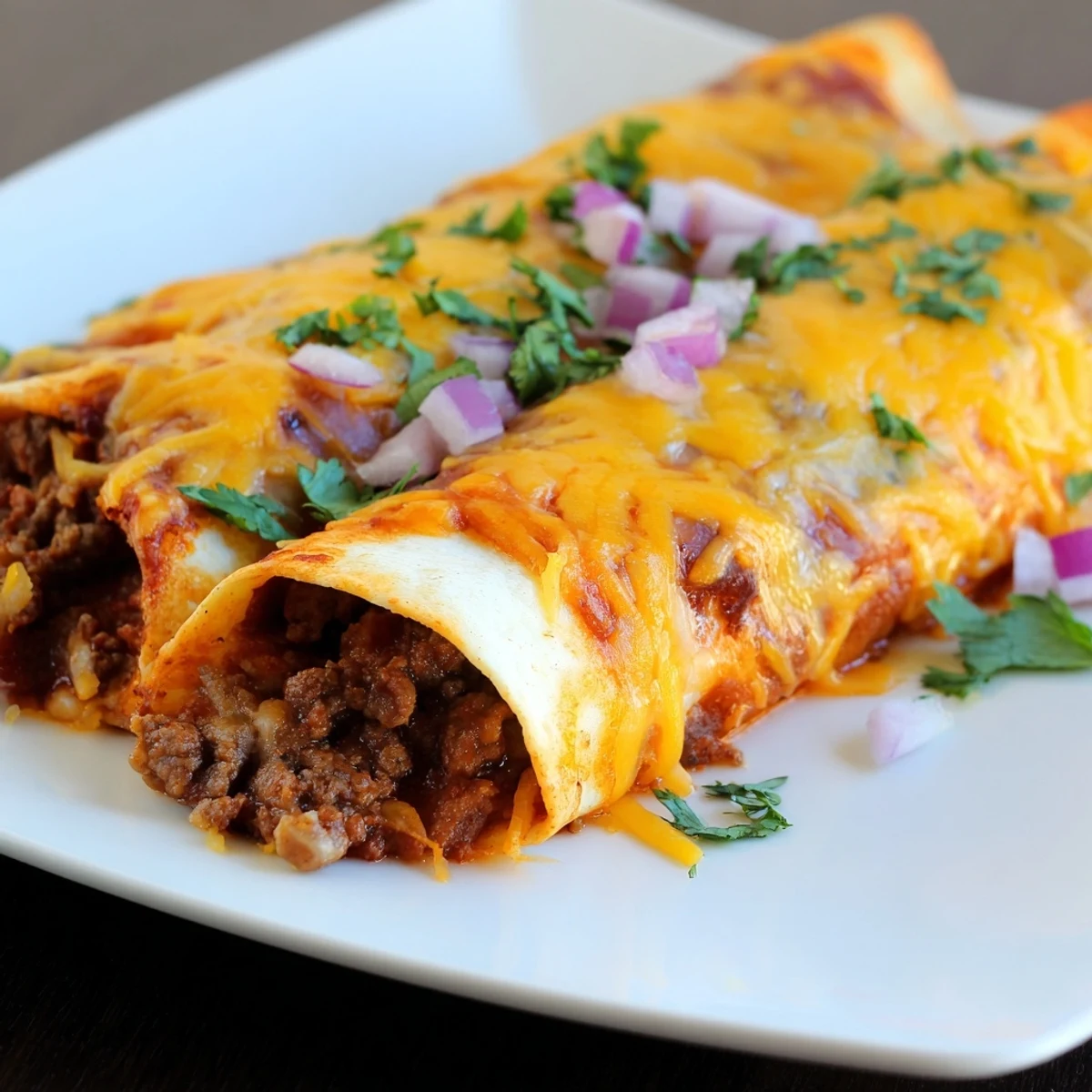 Ground beef filling and homemade red sauce are rolled in warm tortillas and baked until bubbling and golden.