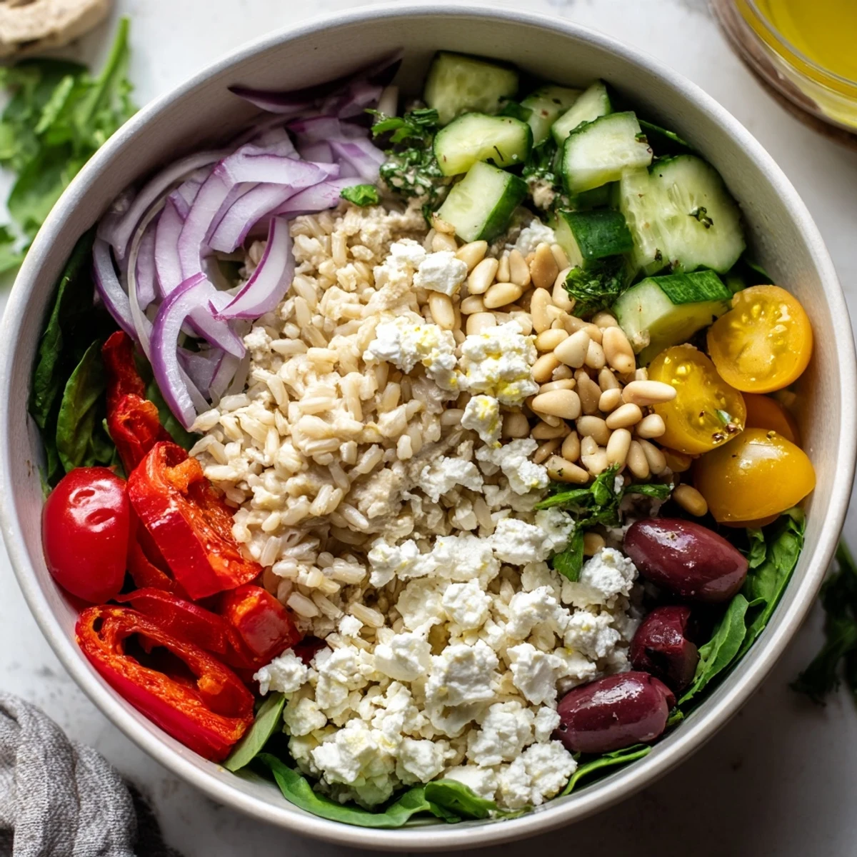 Overhead view of a Mediterranean Hummus Bowl with hummus, quinoa, and fresh vegetables, ready to eat.