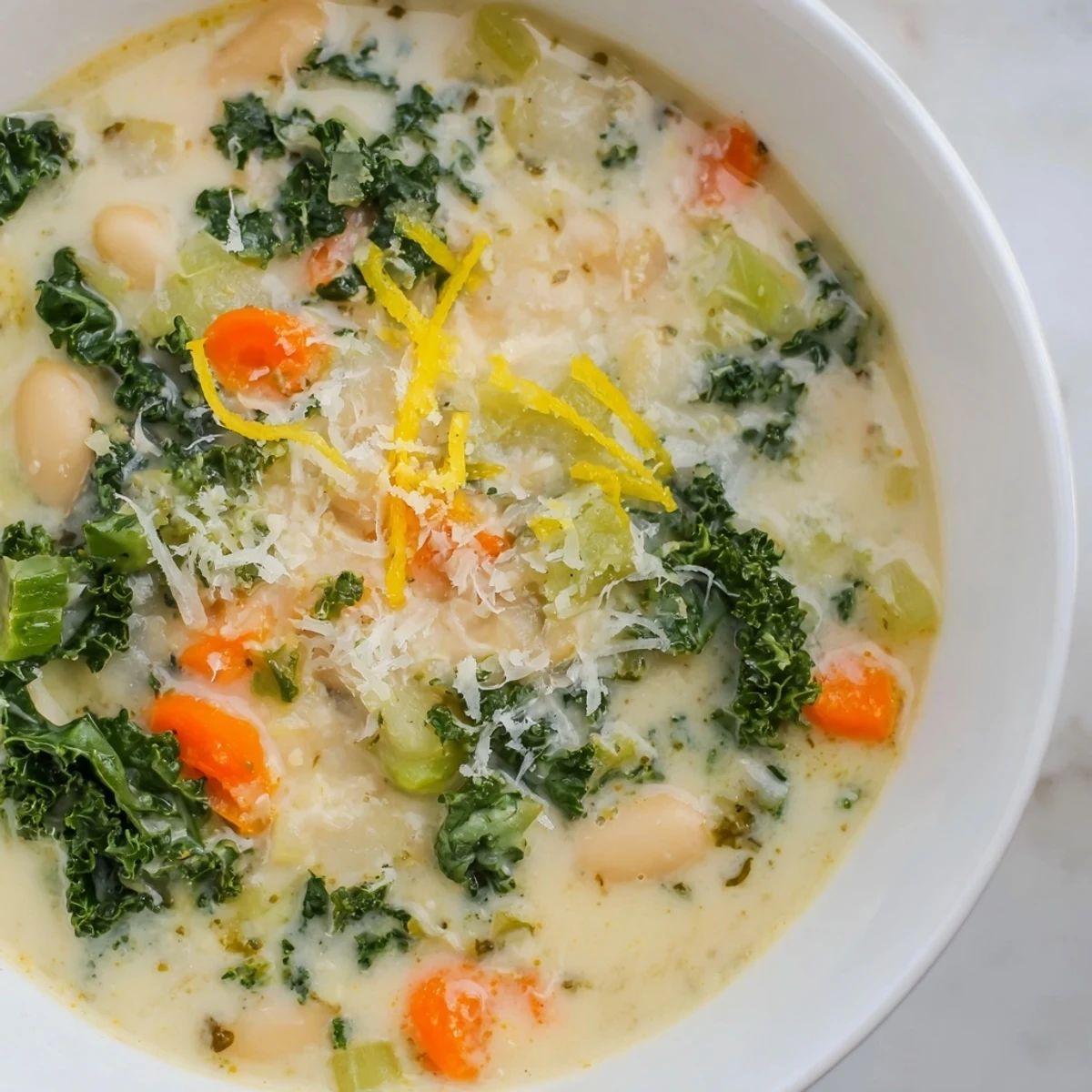 Creamy White Bean and Kale Soup with Lemon Zest and Parmesan in rustic bowls, steam rising and bright green kale glistening.