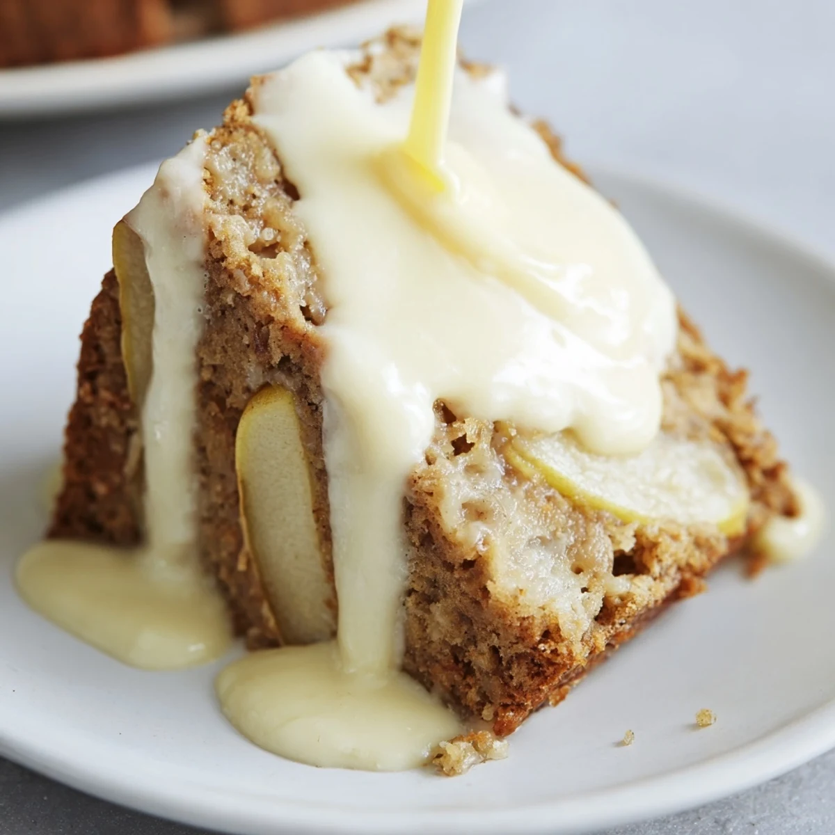 Warm Irish Apple Cake with Custard Sauce, sliced to reveal tender spiced apples inside, drizzled with creamy homemade custard.