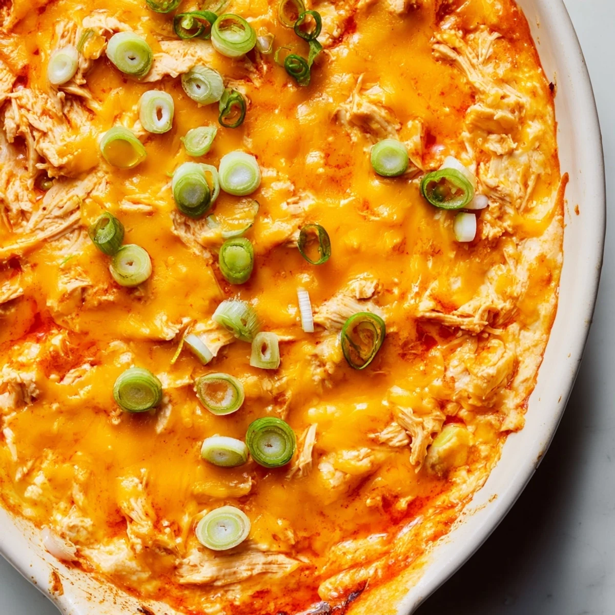 Warm, bubbly Touchdown Buffalo Chicken Dip emerges from the oven with melted cheddar and golden edges, ready for game day.