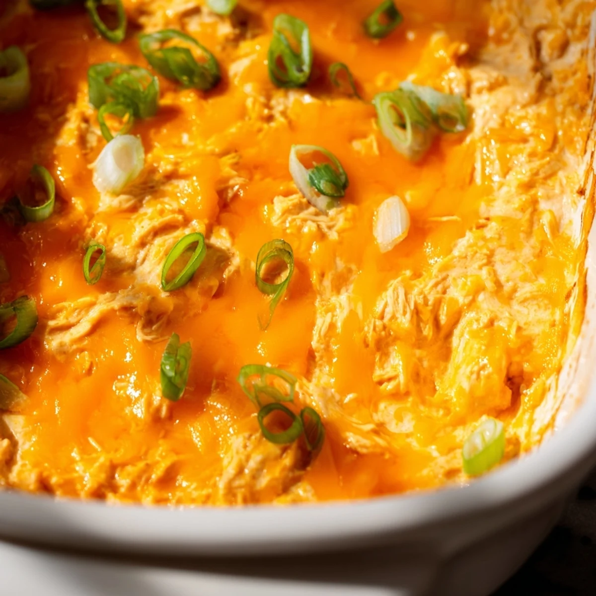 Bubbling, cheesy Touchdown Buffalo Chicken Dip in a baking dish is paired with carrot sticks for a classic game day snack.