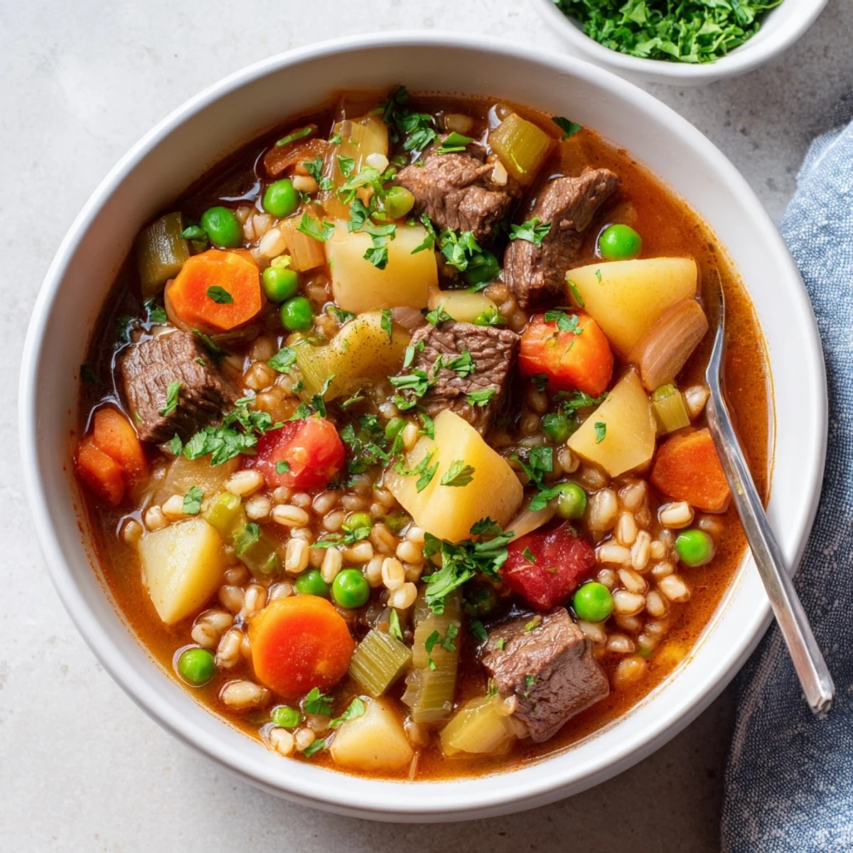 Steaming bowl of Hearty Beef and Barley Vegetable Stew, featuring tender chunks of beef, carrots, and pearl barley in a rich broth.