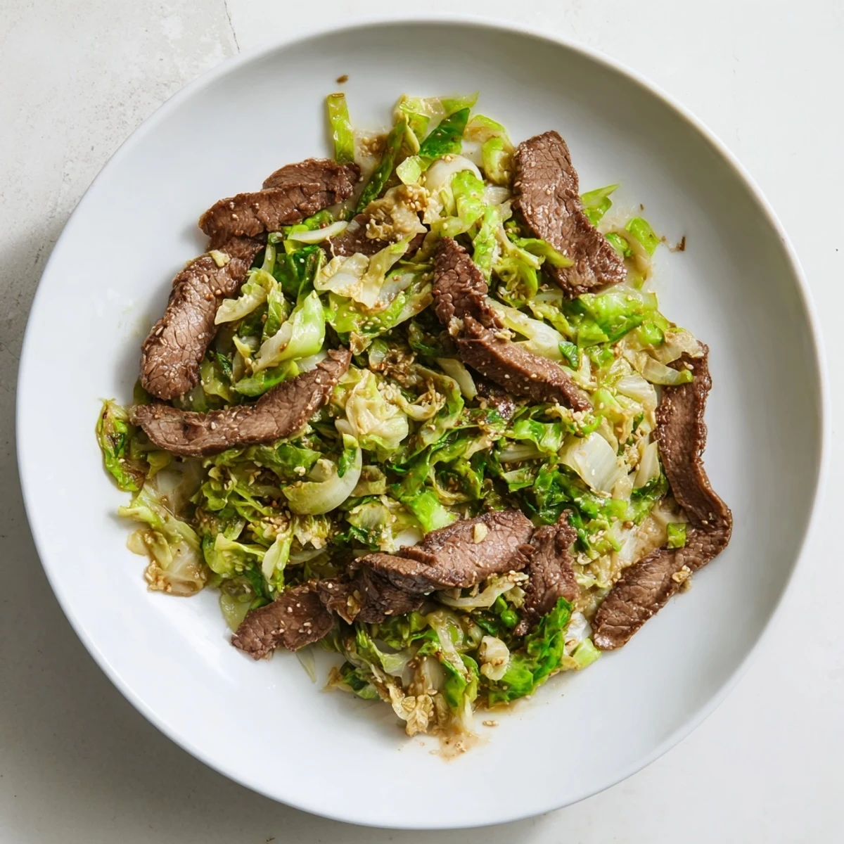 A steaming pan of Keto Friendly Beef and Cabbage Stir Fry, highlighting glistening beef and bright veggies, ready to serve over cauliflower rice.