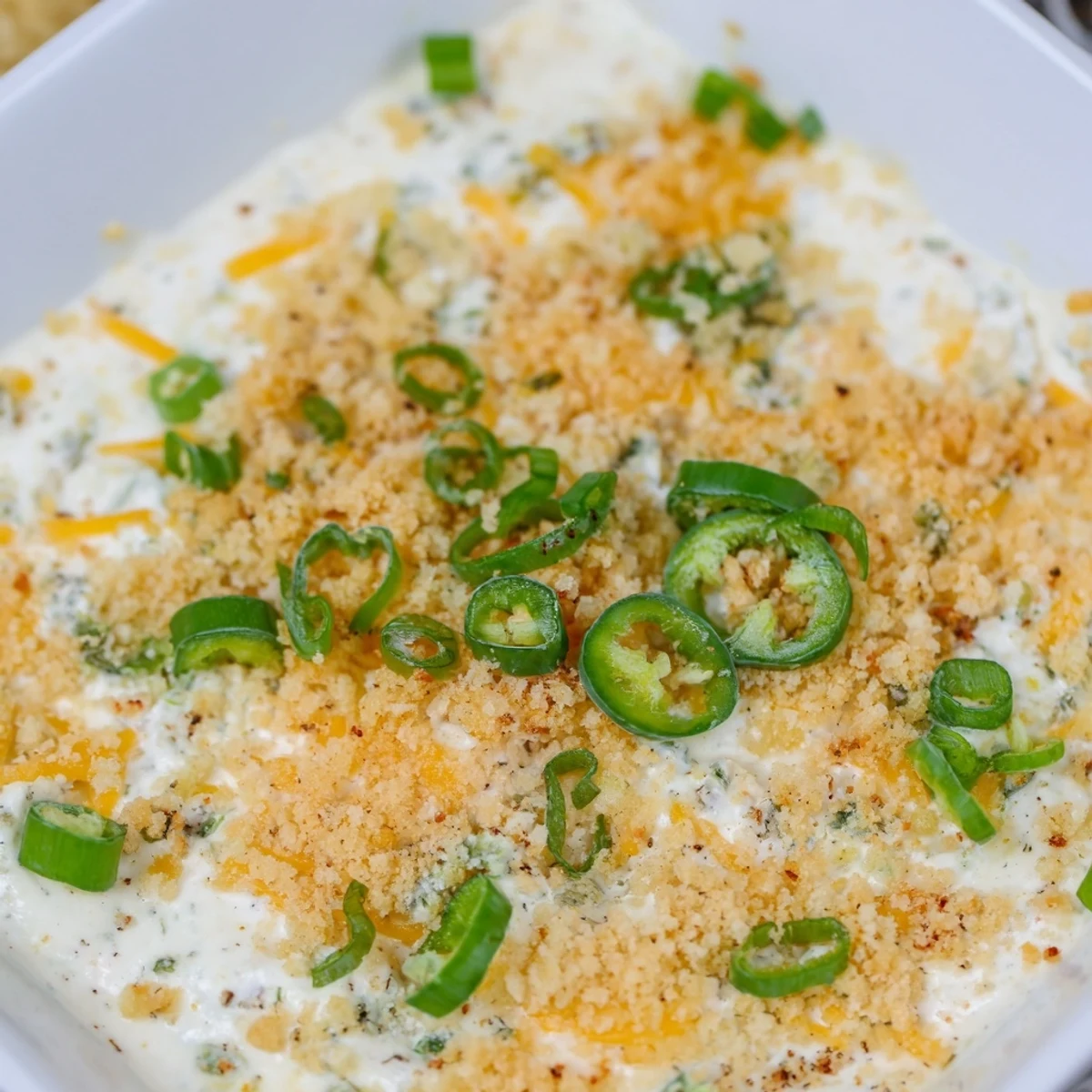 Freshly baked Jalapeno Popper Dip in a rustic dish, topped with crispy panko and melted mozzarella.  