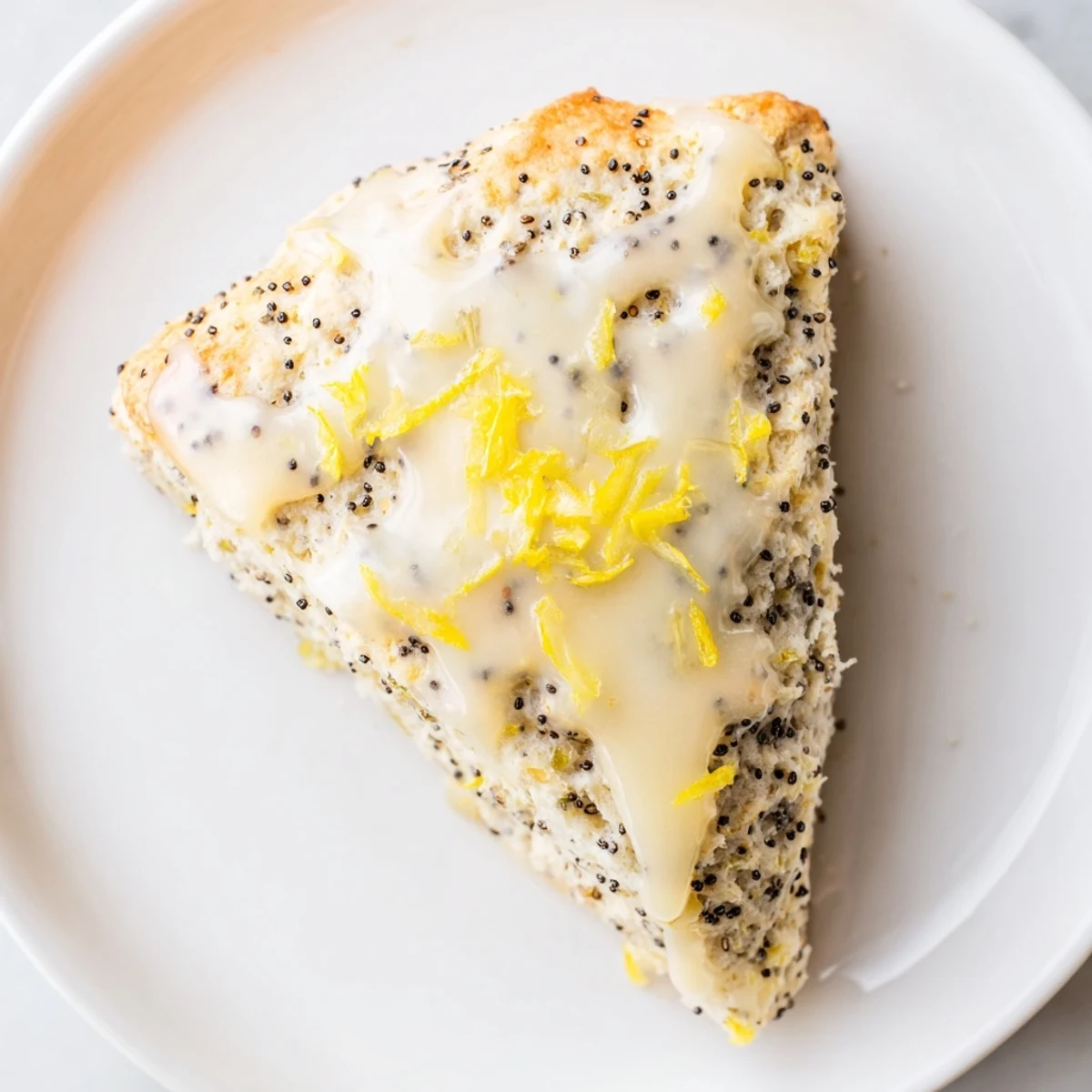 Golden brown Lemon Poppy Seed Scones drizzled with sweet glaze, served warm on a rustic wooden table.
