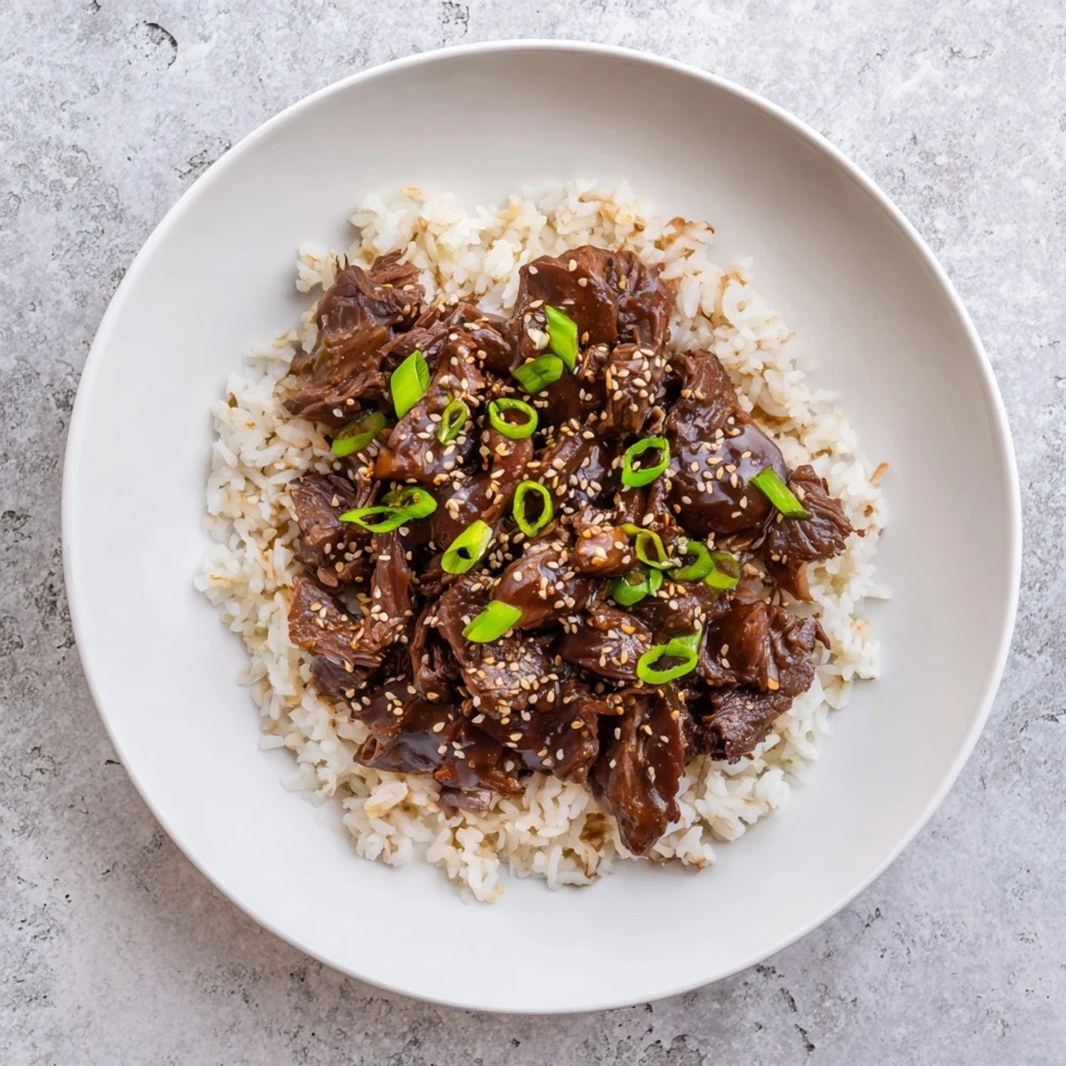 Crock Pot Korean Beef simmering in a rich, glossy sauce served over fluffy jasmine rice.
