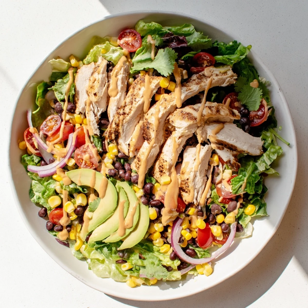 A vibrant chipotle lime chicken salad with grilled meat, crisp veggies, and cilantro garnish ready to enjoy at dinner.