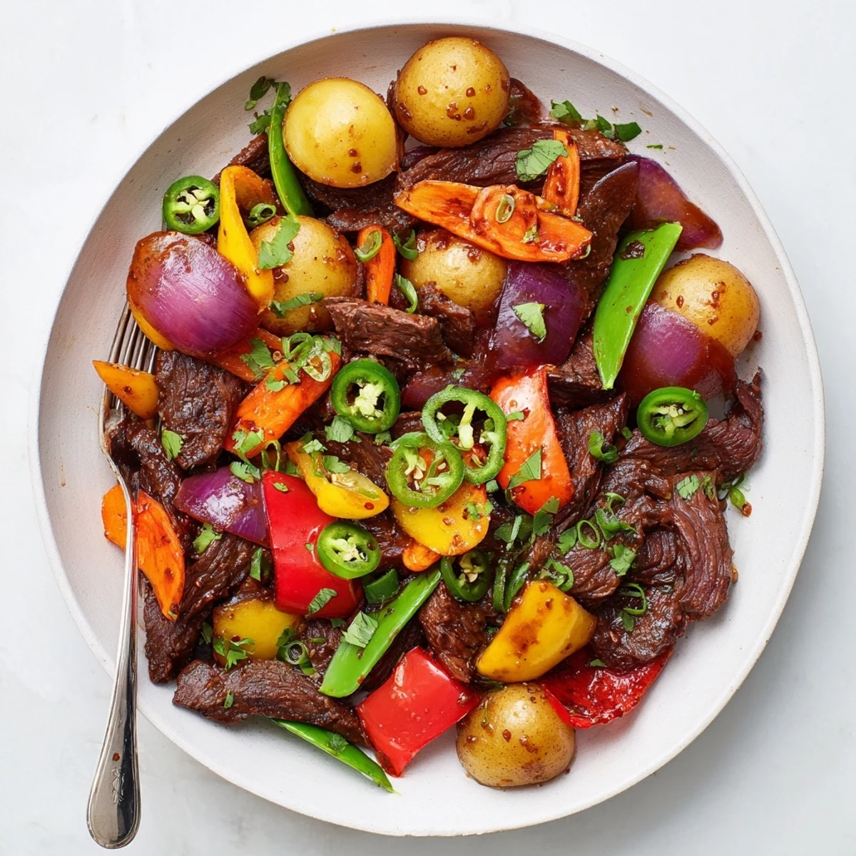 A sizzling Blackstone Cowboy Stir Fry Dinner with seared beef and colorful peppers on the hot griddle.