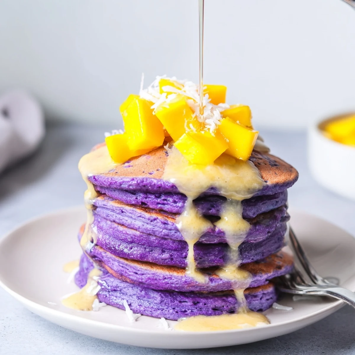 Golden Ube Mochi Pancakes sizzling on a griddle, ready for a sweet brunch.