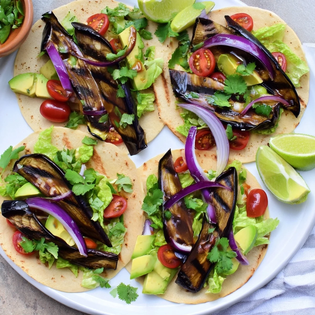 Charred Eggplant Tacos displayed with smoky grilled eggplant slices, fresh toppings, and lime wedges on warm tortillas.