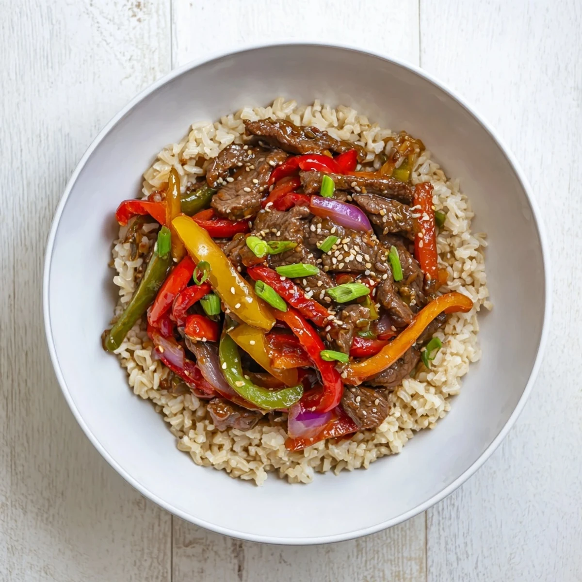Healthy beef and pepper rice bowl with tender strips of beef and colorful sliced bell peppers