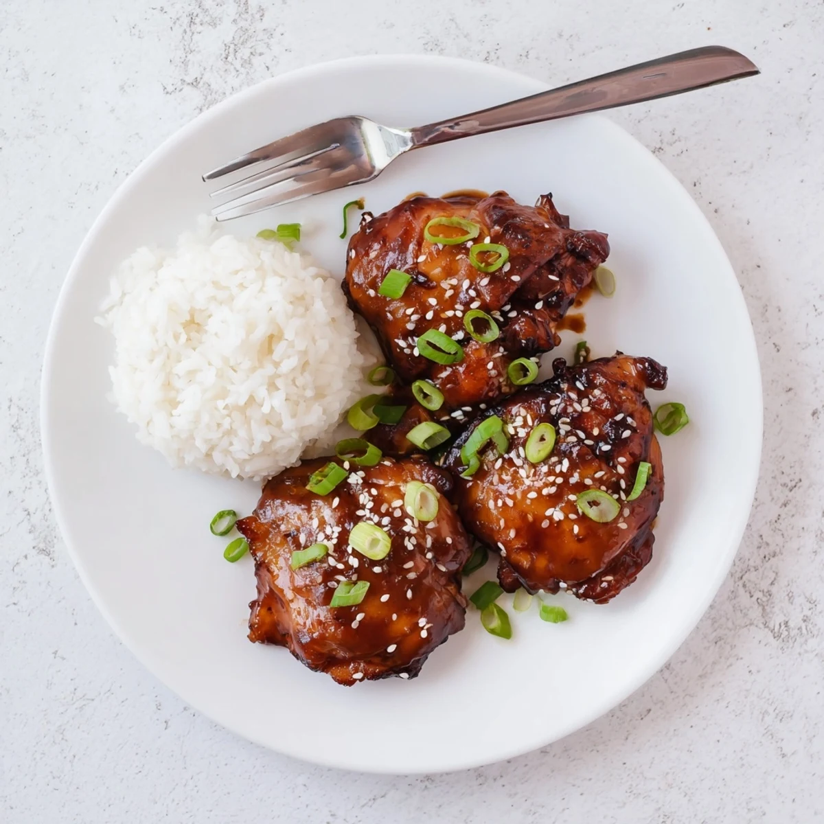 Golden glazed slow cooker chicken pieces coated in thick pineapple soy sauce with sesame seed garnish