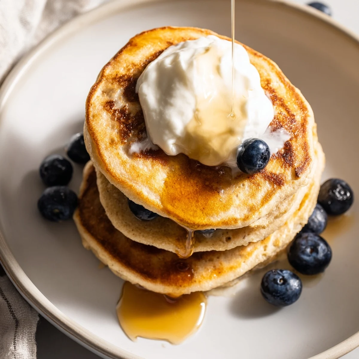 Homemade banana oatmeal pancakes served with Greek yogurt and sliced banana breakfast spread