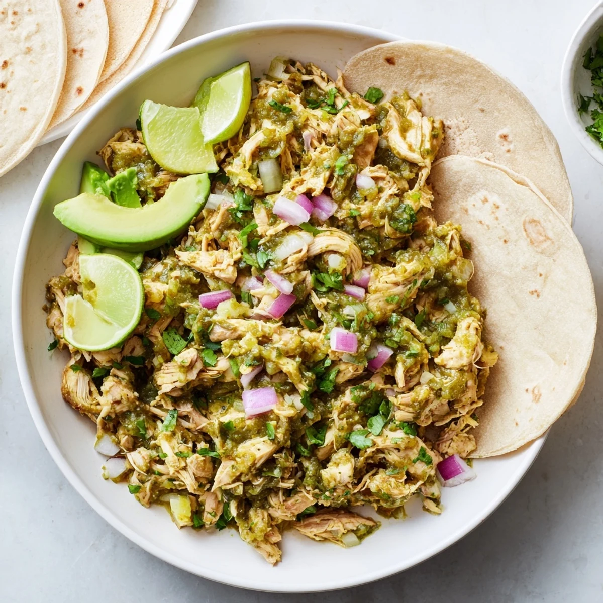 Tender shredded chicken coated in zesty salsa verde sauce served in warm corn tortillas