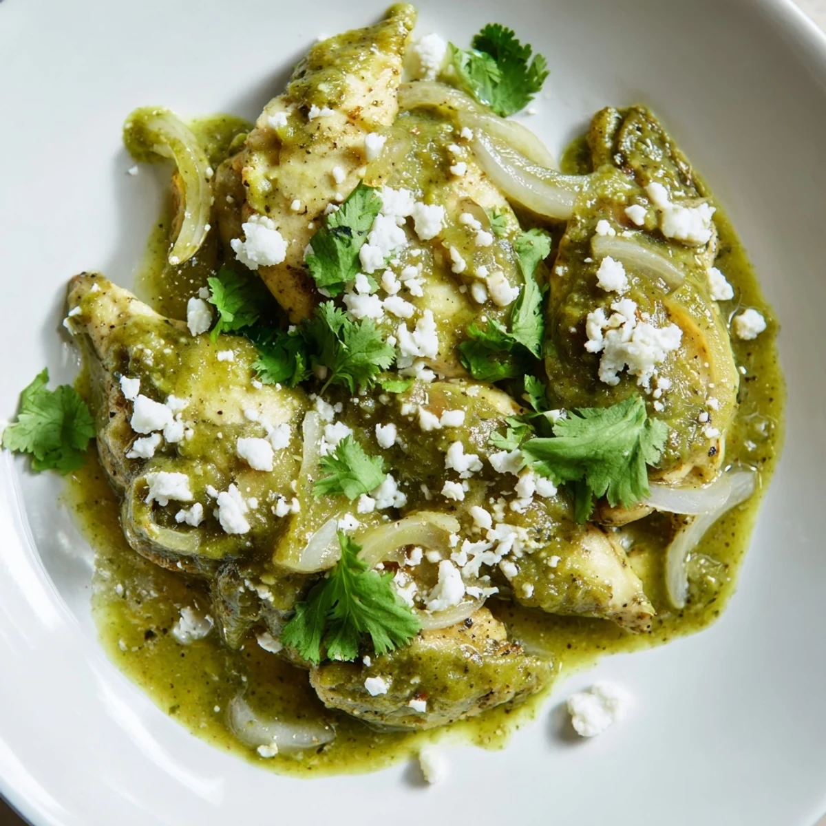 Golden seared chicken nestling in tangy tomatillo salsa verde sauce topped with crumbled queso fresco and lime.