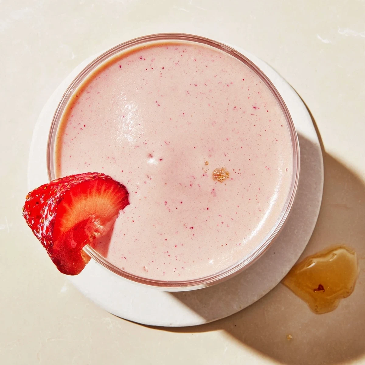 Thick creamy strawberry smoothie with Greek yogurt topped with fresh strawberry slices
