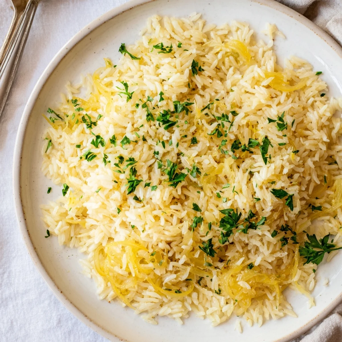 Creamy French onion butter rice served in white bowl with melted Gruyère topping