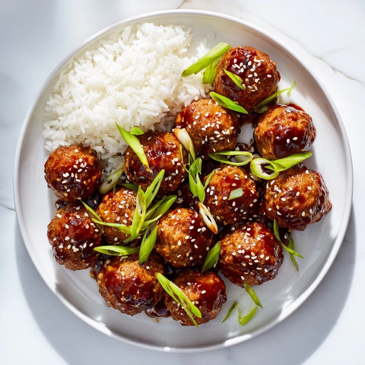 Golden brown Japanese chicken meatballs glazed in sticky homemade teriyaki sauce with sesame seeds