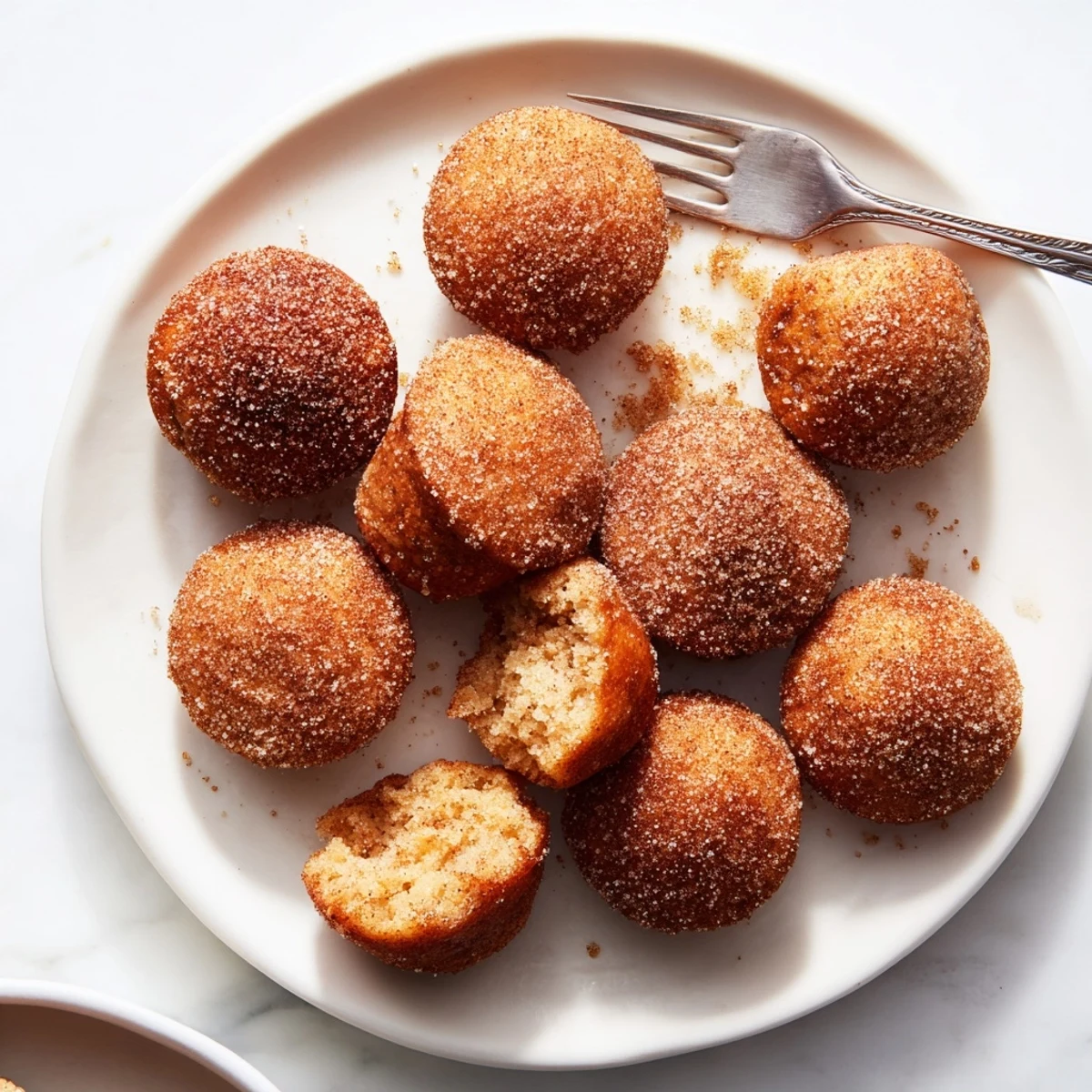 Warm bite-sized cinnamon sugar mini muffins arranged on a wire rack ready for breakfast snacking