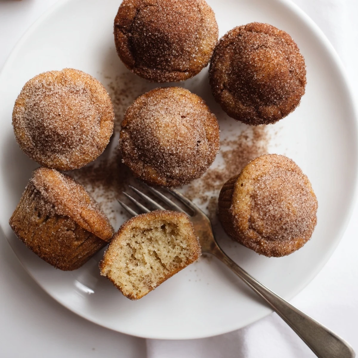 Tender homemade cinnamon sugar mini muffins coated in buttery cinnamon sugar on a serving platter