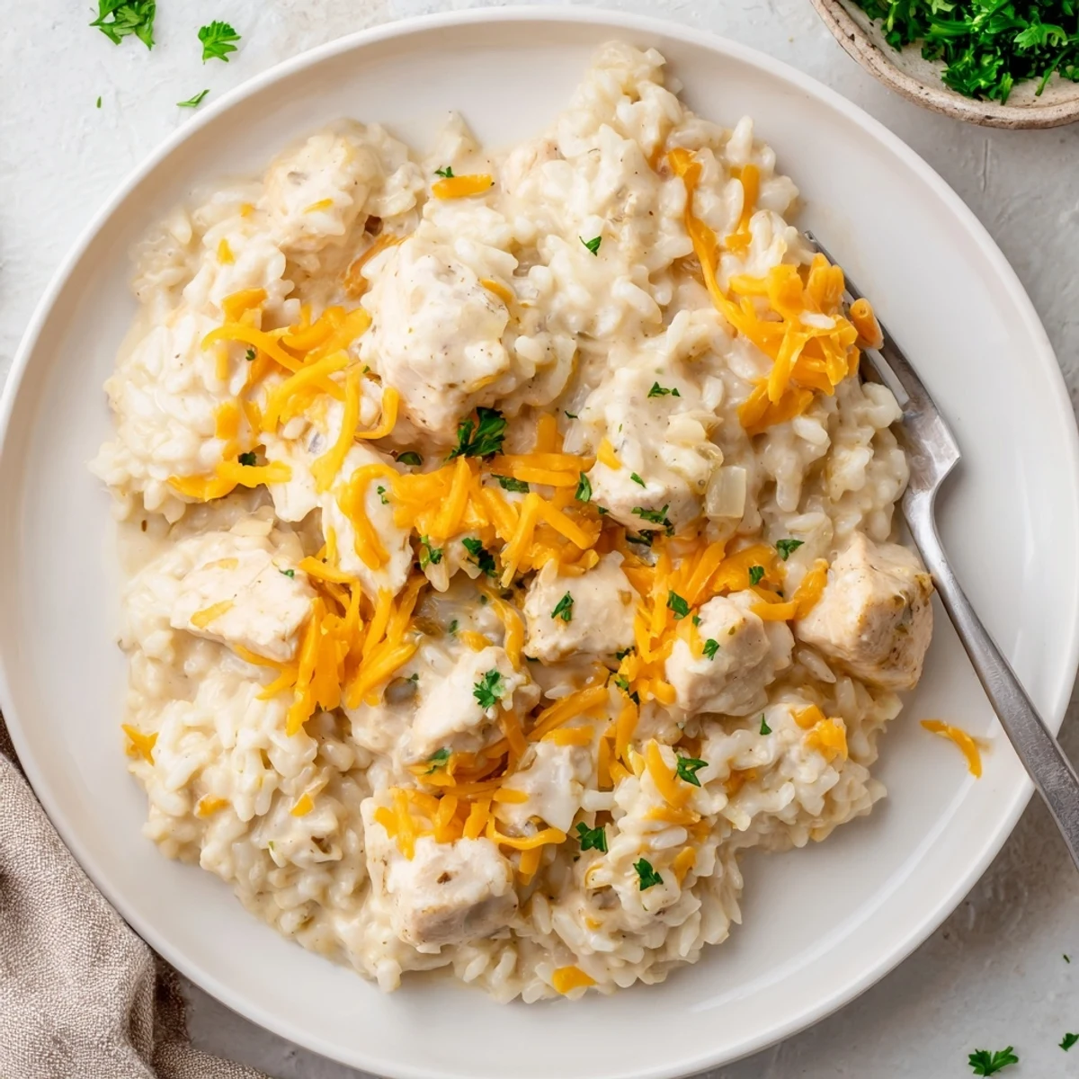 Golden chicken breasts nestled in creamy rice with melted cheddar cheese topping