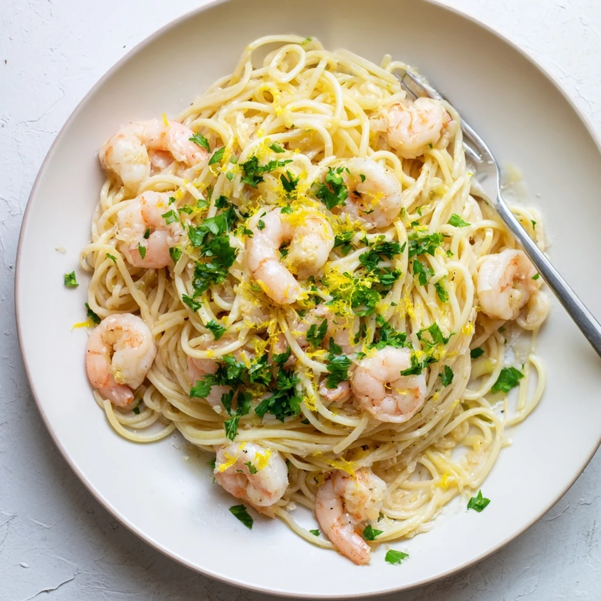 Steaming plate of shrimp scampi pasta featuring al dente noodles coated in white wine garlic butter