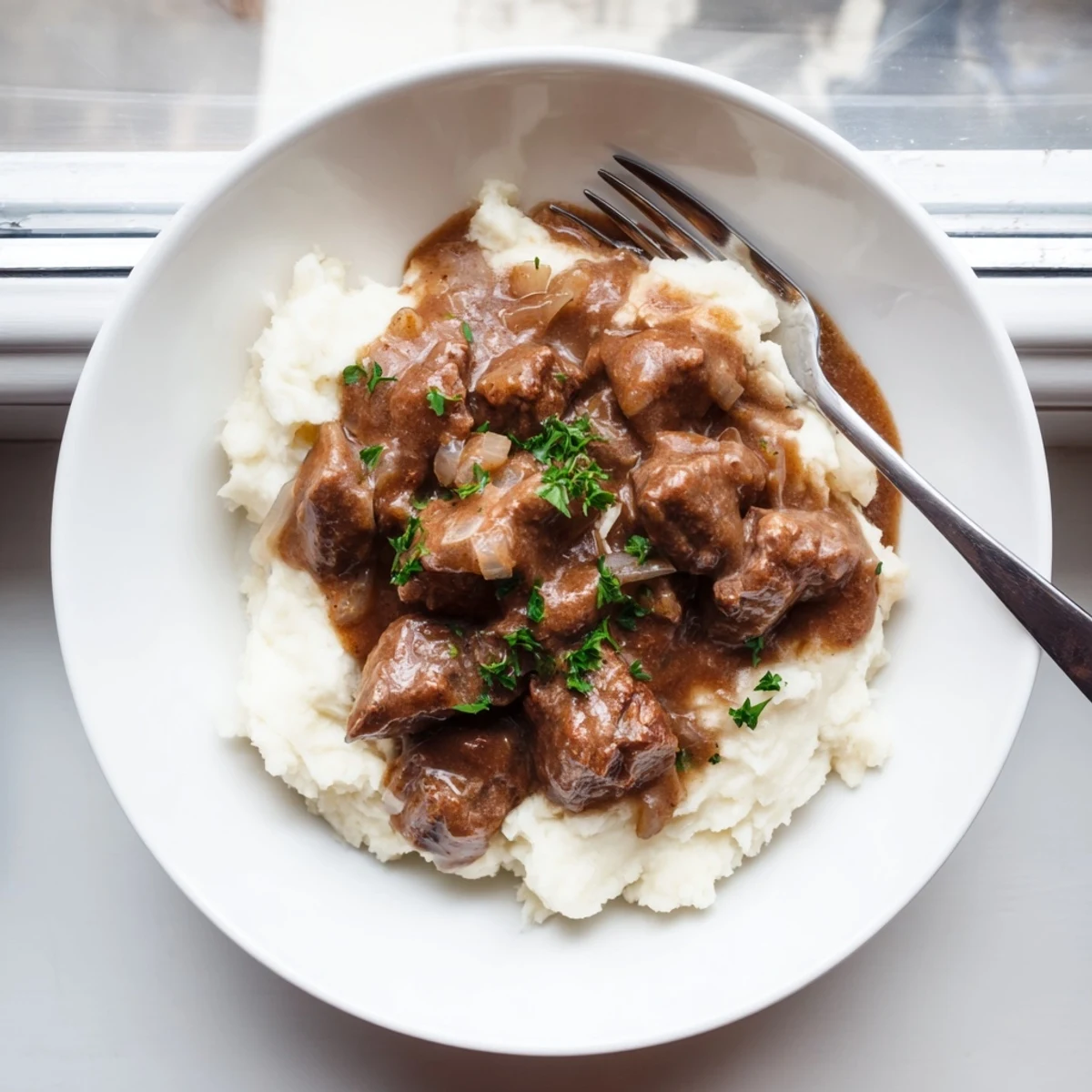 Tender beef simmering in rich brown gravy alongside buttery egg noodles for a comforting meal