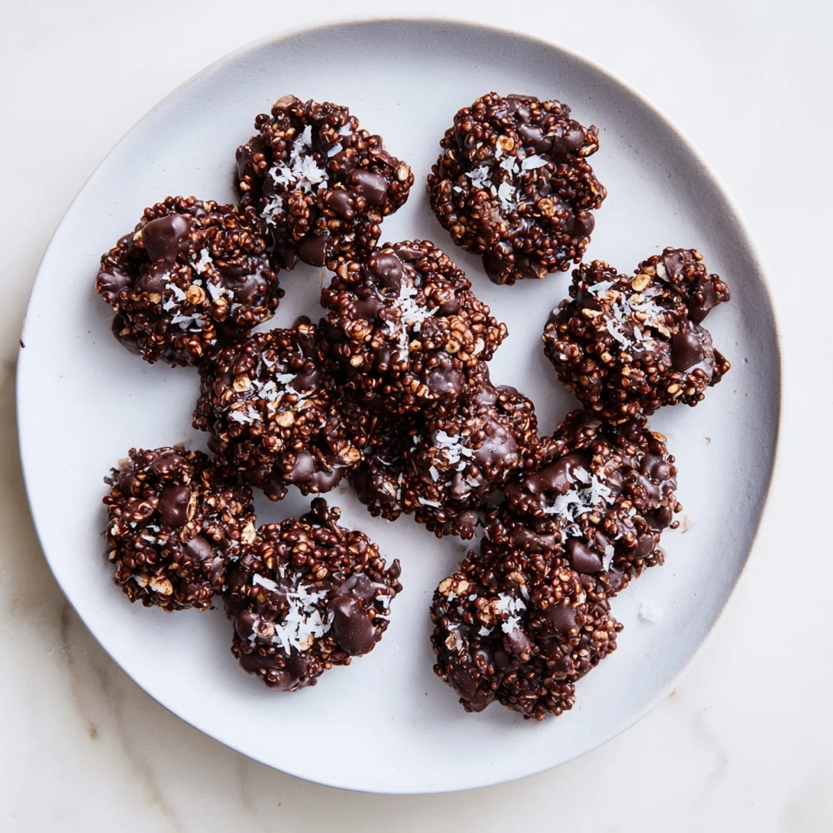 Hand holding a crunchy dark chocolate quinoa crisp showing the toasted texture
