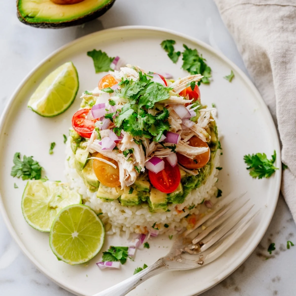 Golden honey lime chicken stacked over fluffy rice with creamy avocado and fresh garnishes