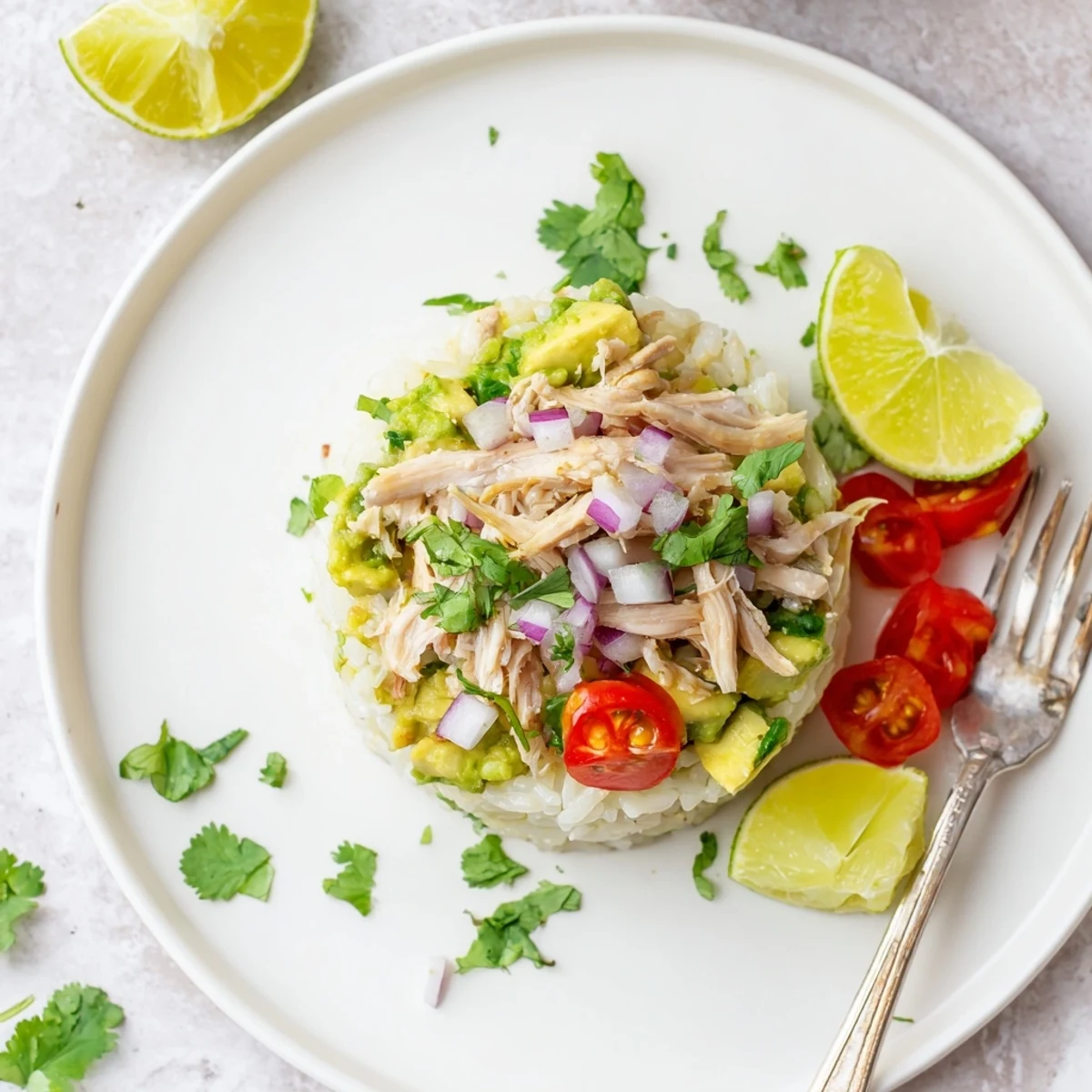 Tall honey lime chicken avocado rice stack with tender sliced meat and lime wedges