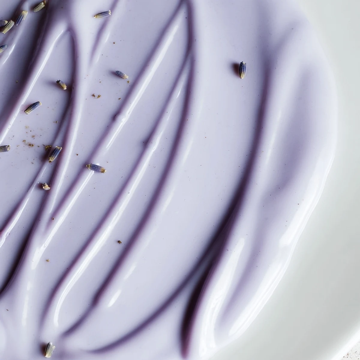 Glossy lavender glaze pooling on a porcelain spoon ready for drizzling over scones
