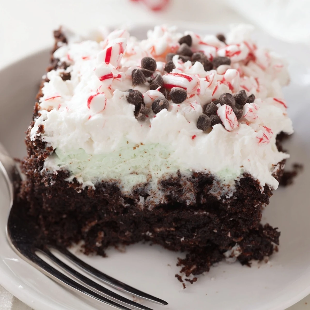 Slice of Peppermint Poke Cake showing glossy pudding filling and minty aroma  