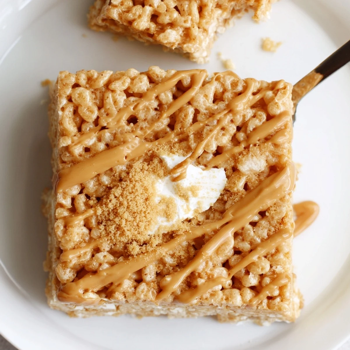 Warm Biscoff Rice Krispie Treats cooling on parchment, buttery caramel aroma