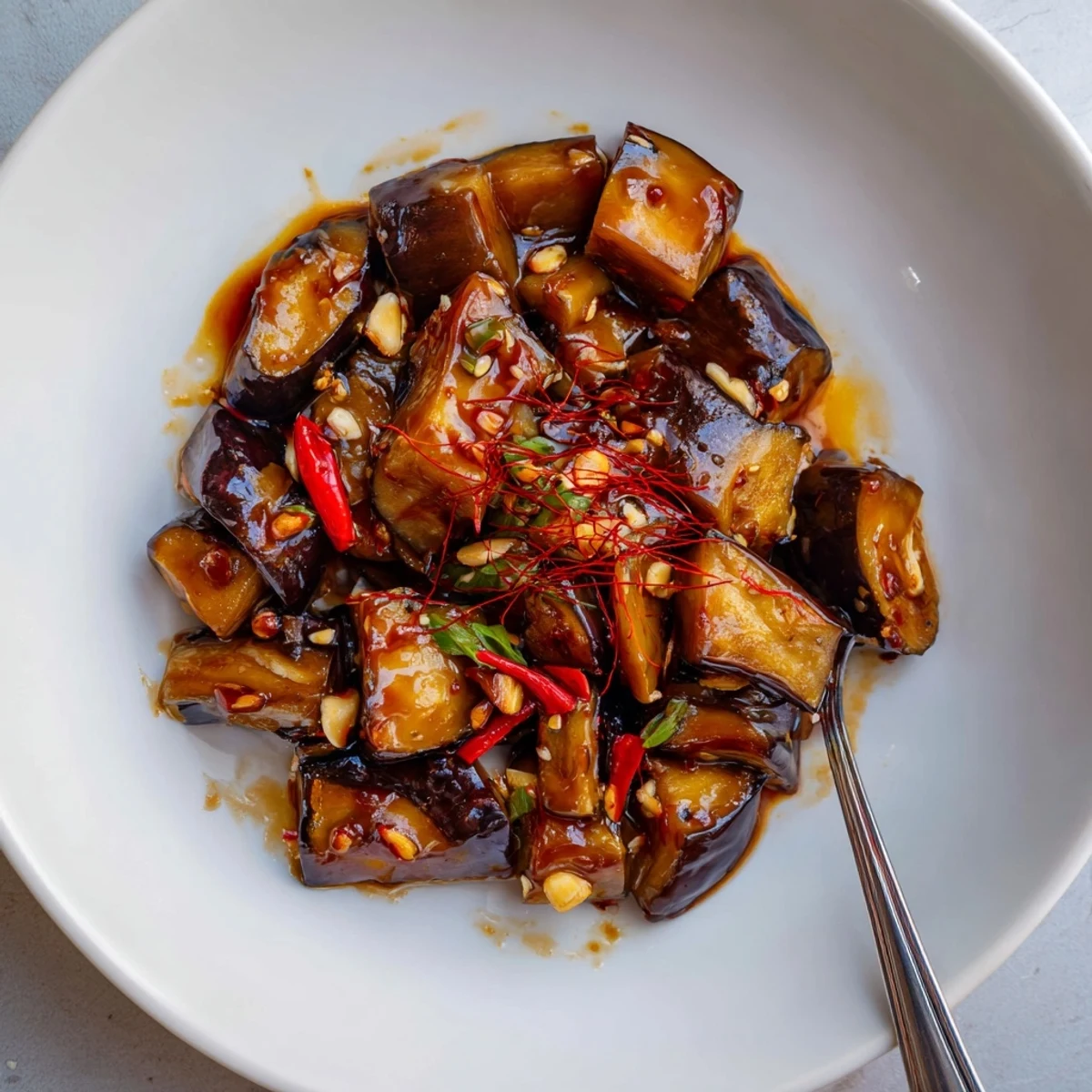 Sichuan Style Braised Aubergines glistening in spicy red sauce, scallions, jasmine rice.