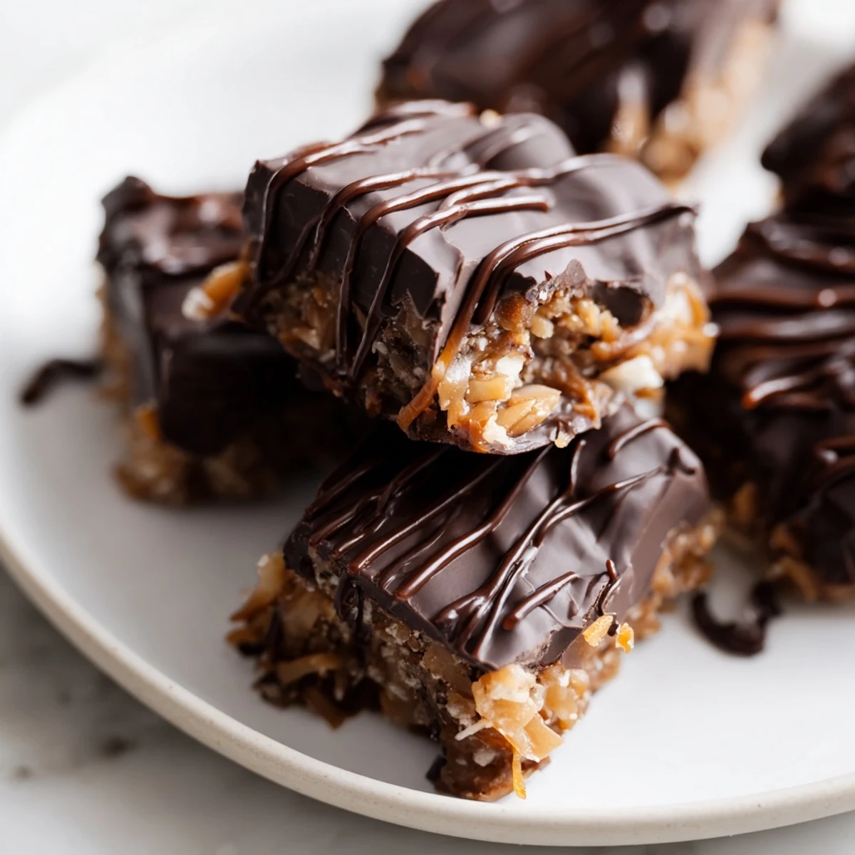 Golden no bake Samoa bites drizzled with melted dark chocolate and toasted coconut flakes