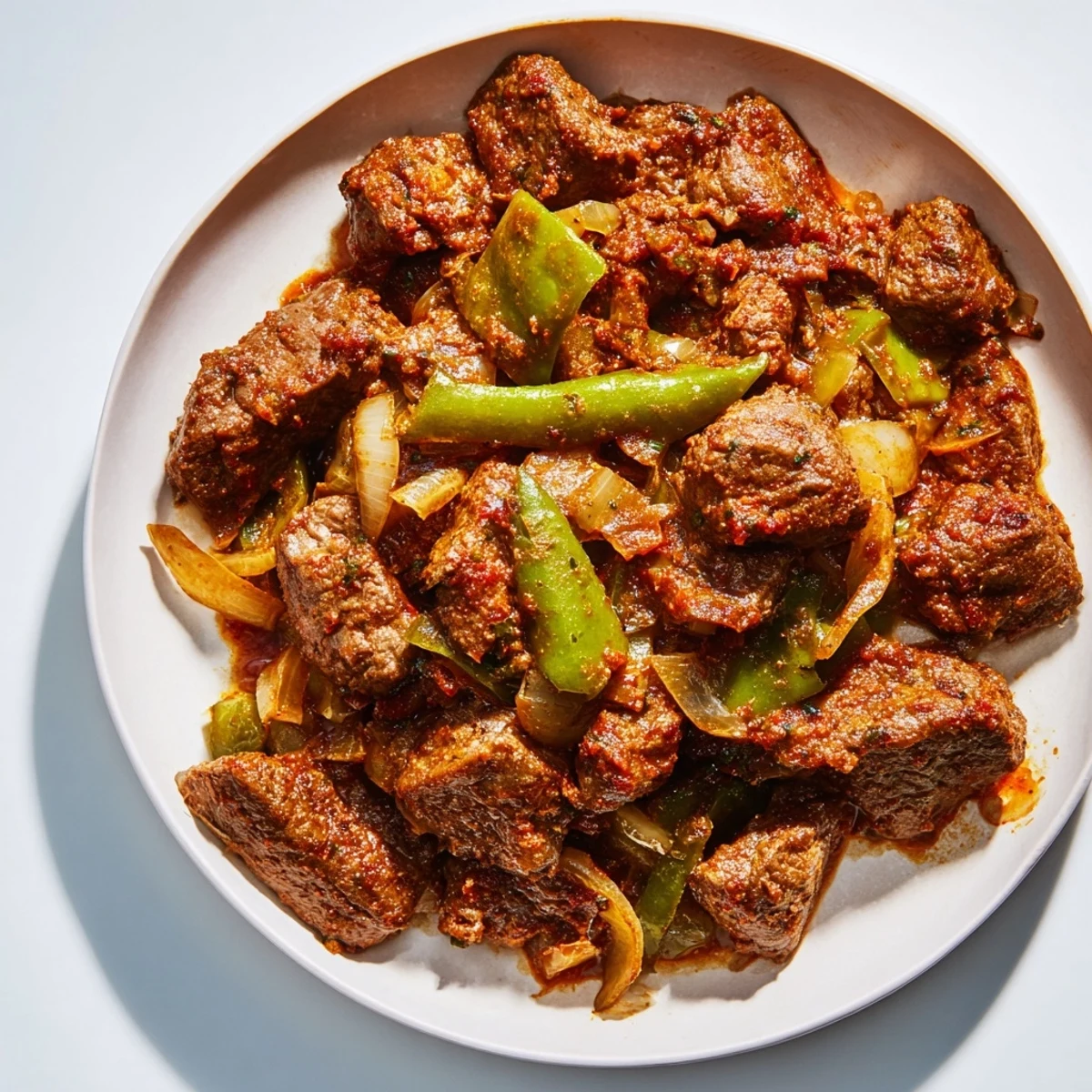 Golden old fashioned Swiss steak with beef served over creamy mashed potatoes with rich tomato sauce