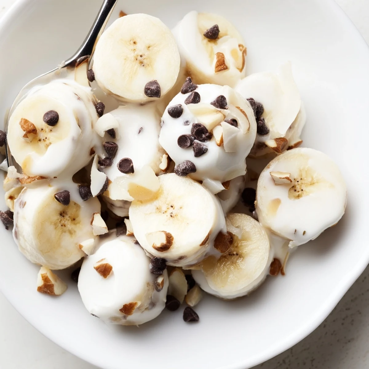 Close-up of Frozen Banana Yogurt Bites showing creamy coating and crunchy nuts  