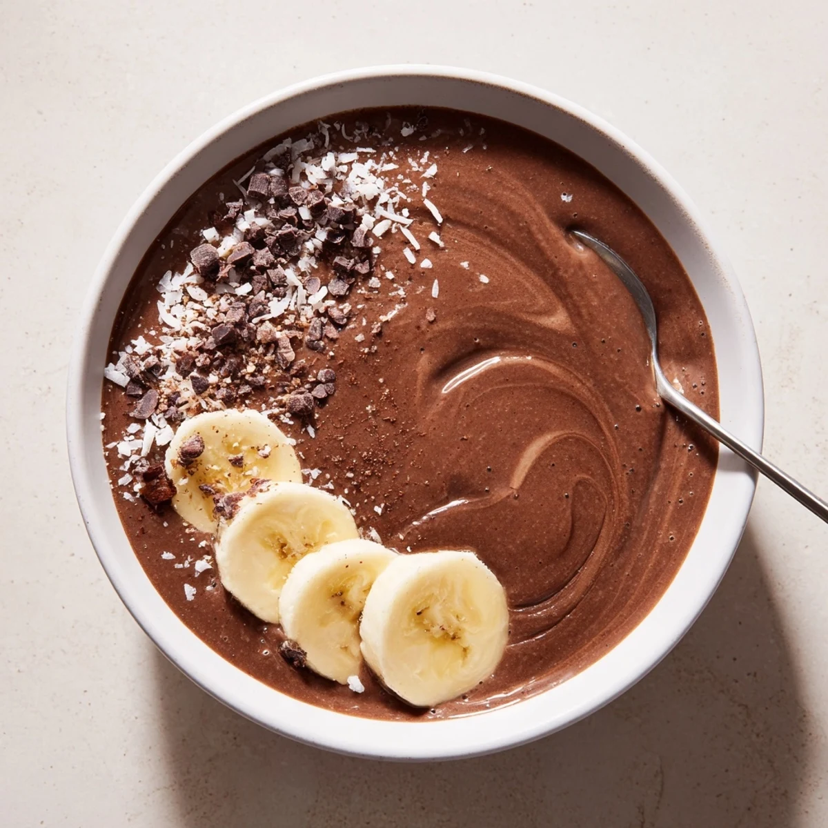Raw Chocolate Banana Shake poured into glass, creamy texture, sliced banana garnish