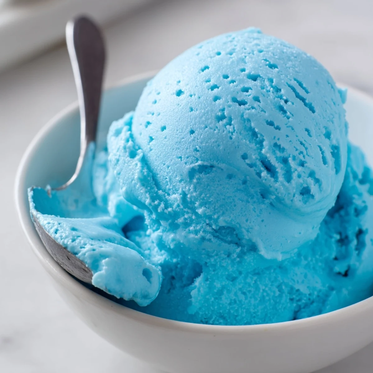 Vibrant Blue Moon Ice Cream with a smooth texture scooped atop a sugar cone