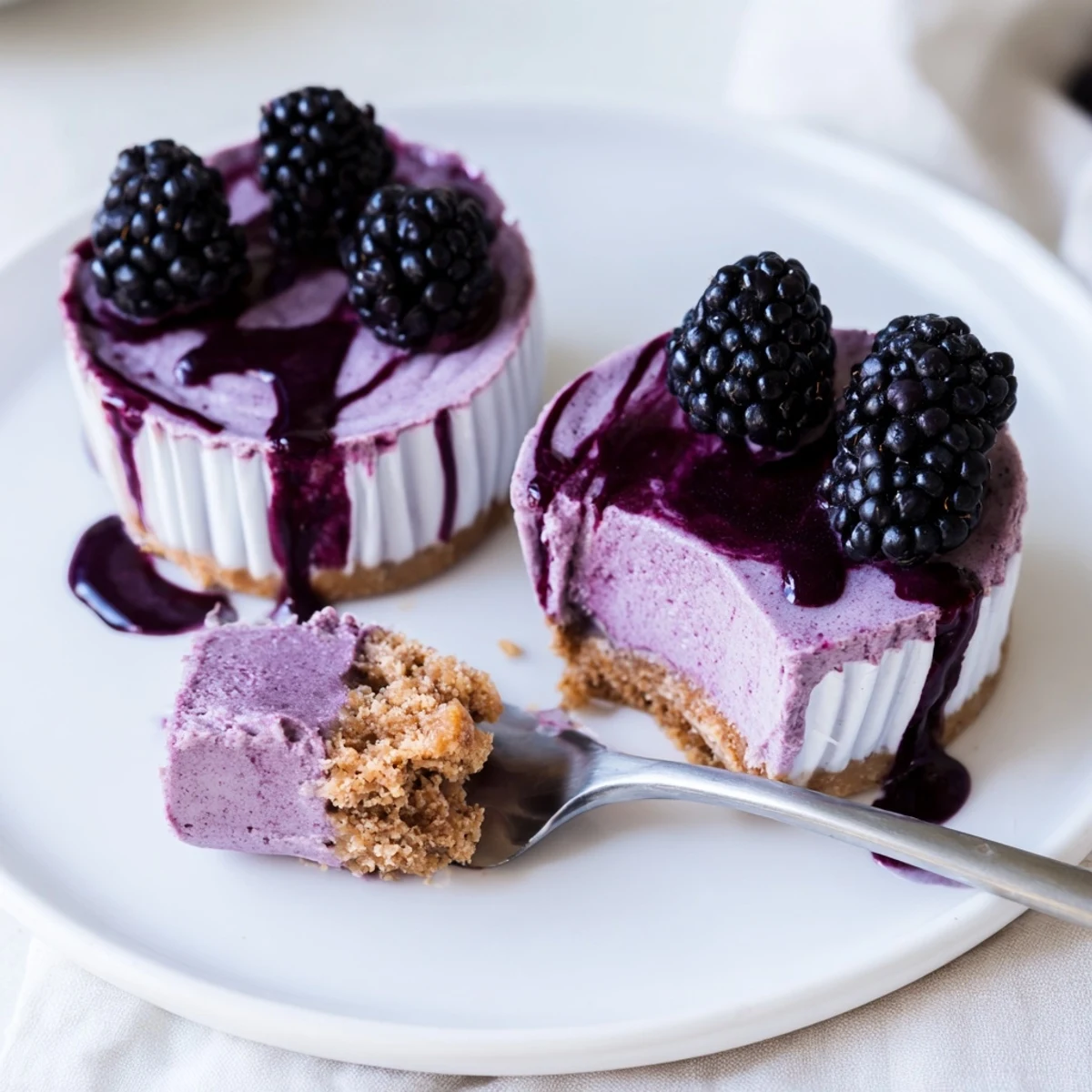 Creamy No Bake Mini Blackberry Lavender Cheesecakes swirled with vivid purple berry filling